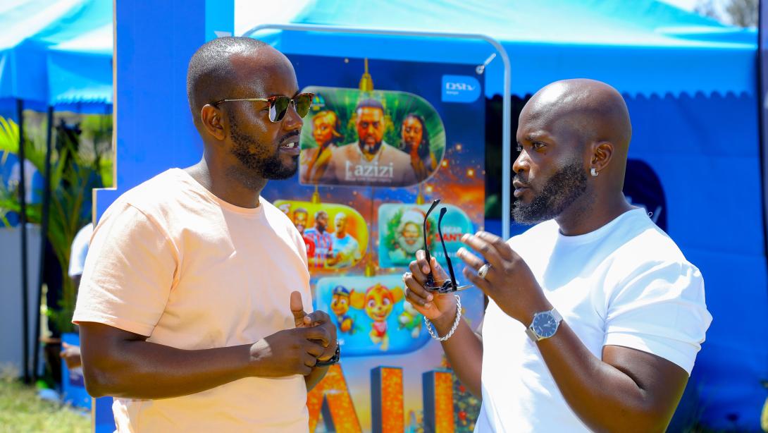 PIC 1   From L to R Elisha Kamau, Public Relations Manager at MultiChoice Kenya, engages in conversation with Alex Khayo, who plays Sting on Qware, during the MultiChoice Krisi Festival Activation at Nyayo Estate.