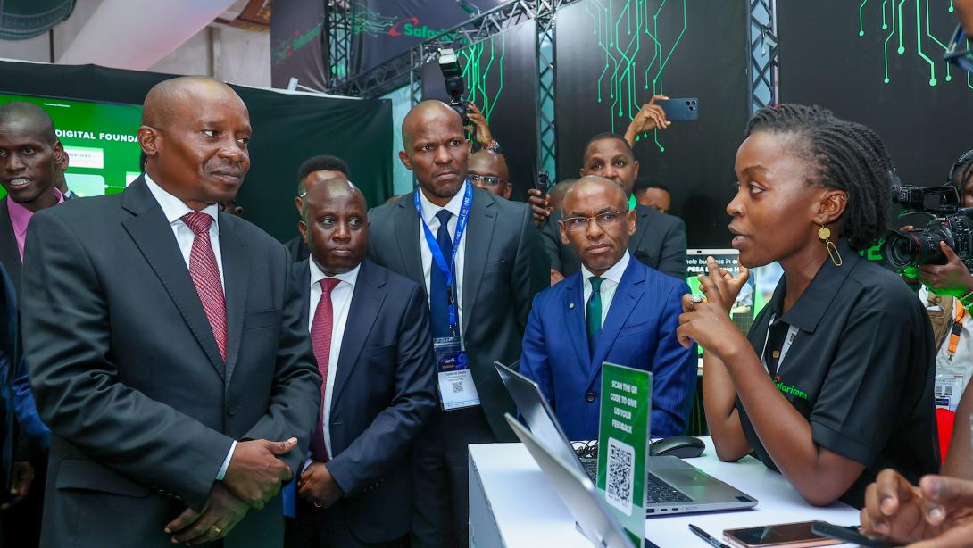 At the Connected Africa Summit 2026, took place at the Edge hotel in Nairobi County, Faith Kuya (R), Technical Lead, DPI Tribe at Safaricom PLC, show some of the company's products to Prof. Kithure Kindiki, Deputy President and  Peter Ndegwa, Group Chief Executive Officer. The event was held at the Edge Hotel Nairobi County.