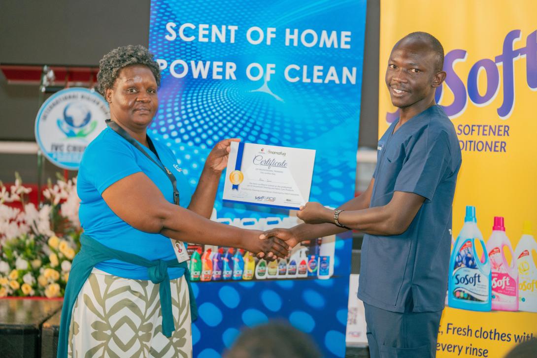 HACO Industries Home care Category Manager, Joan Chege (L) presenting a certificate to Brian Juma a participant(R) after a successful completion of the training.