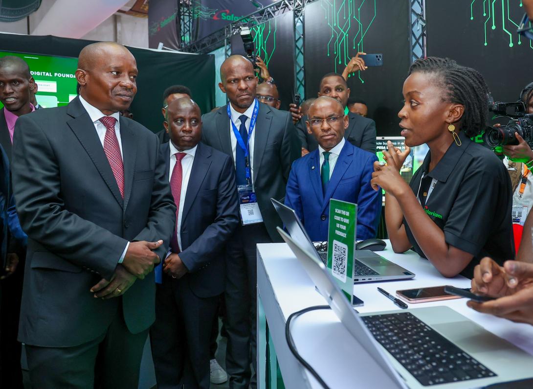 At the Connected Africa Summit 2026, took place at the Edge hotel in Nairobi County, Faith Kuya (R), Technical Lead, DPI Tribe at Safaricom PLC, show some of the company's products to Prof. Kithure Kindiki, Deputy President and  Peter Ndegwa, Group Chief Executive Officer. The event was held at the Edge Hotel Nairobi County.