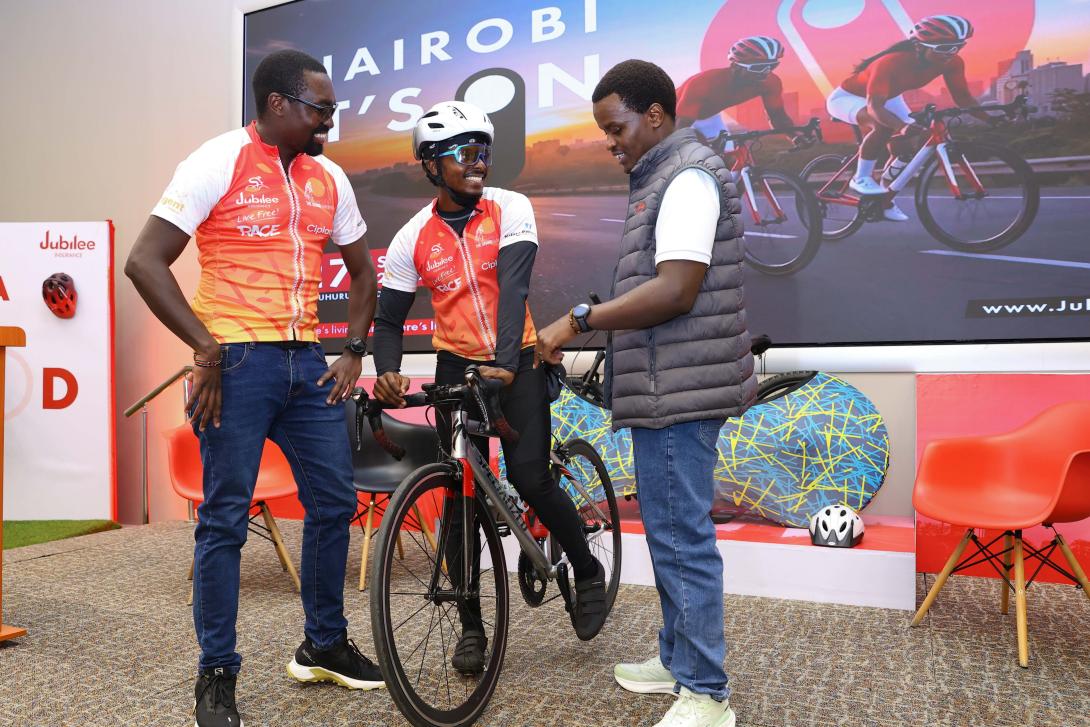 Jubilee Group Marketing and Corporate Communications Manager Peter Kibe with Team Syke Cyclist Bullet Macharia and Grand Nairobi Bike Race Logistics Manager Grace Wambui during the launch of the sixth edition Jubilee Live Free Race. This year's event will be hosted at Uhuru Gardens and will traverse the Southern Bypass route.