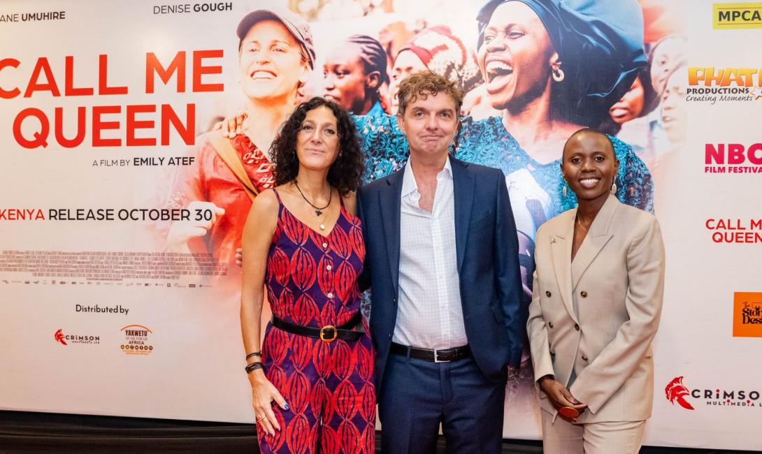 Three attendees pose in front of a Call Me Queen promotional backdrop at the film’s Nairobi premiere.